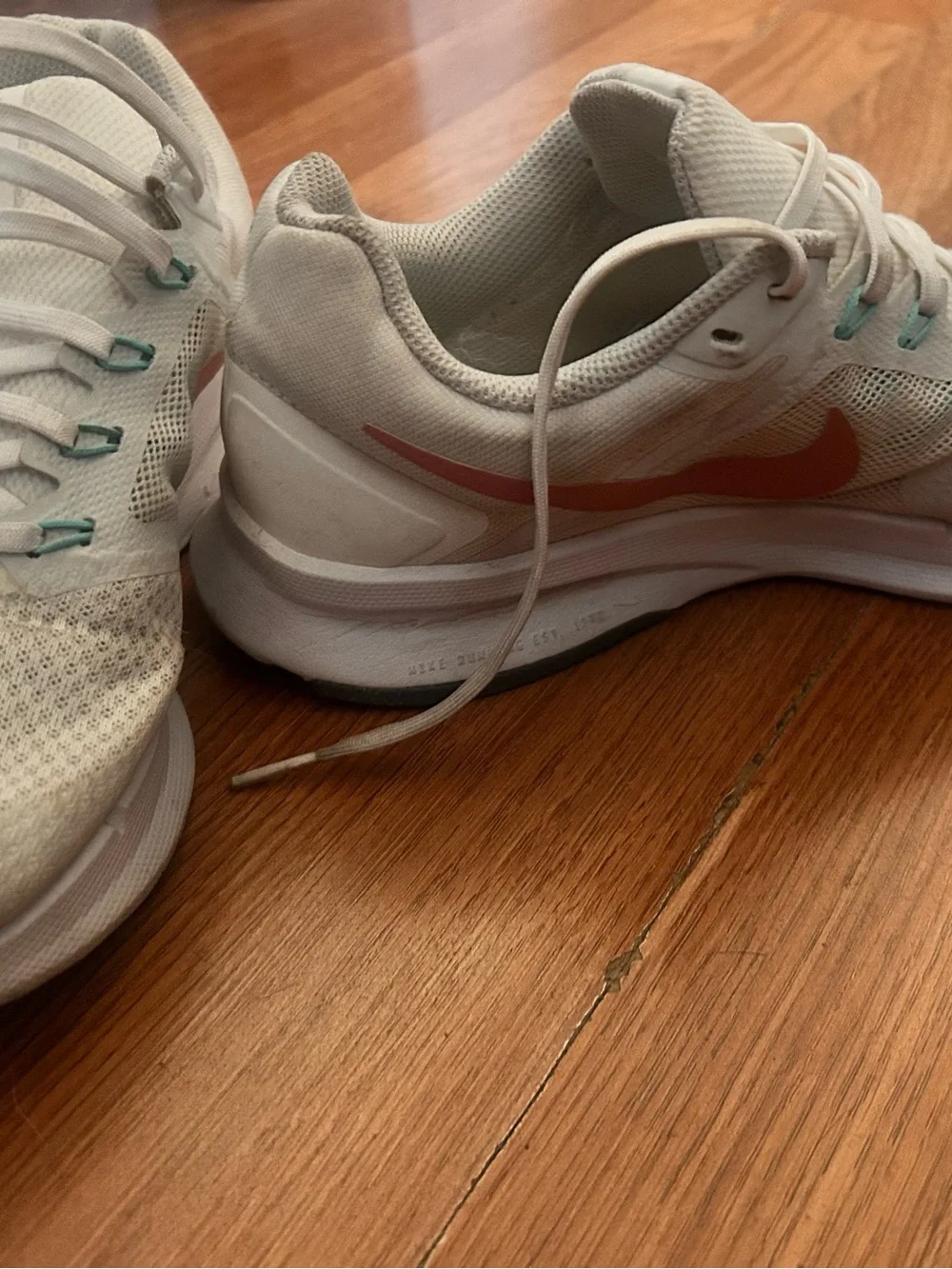 Nike Women's White Sneakers with Coral Swoosh and Teal Accents